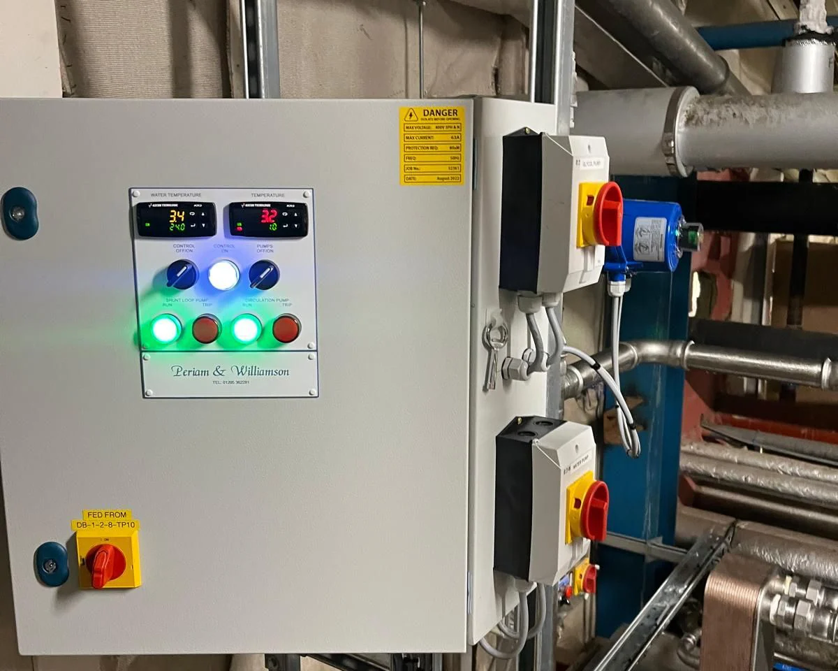 Electrical control panel with illuminated selector switches and a Periam & Williamson name plate, fitted in a plant room