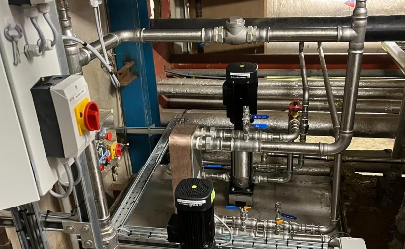 Industrial plant room with pipework, pumps and electrical isolators