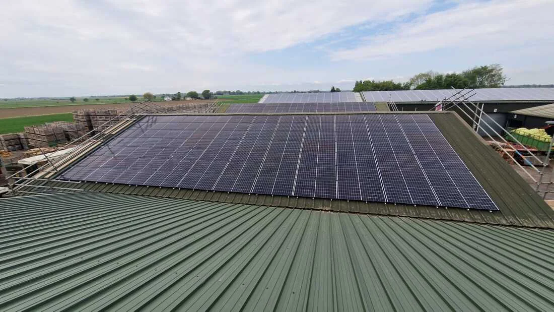 Solar PV panel array on a green profiled metal roof