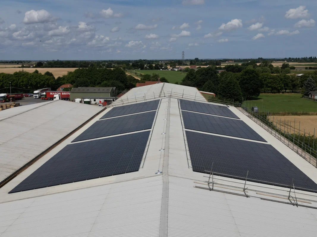 Aerial view of solar PV panels on the pitched roof of a large industrial building